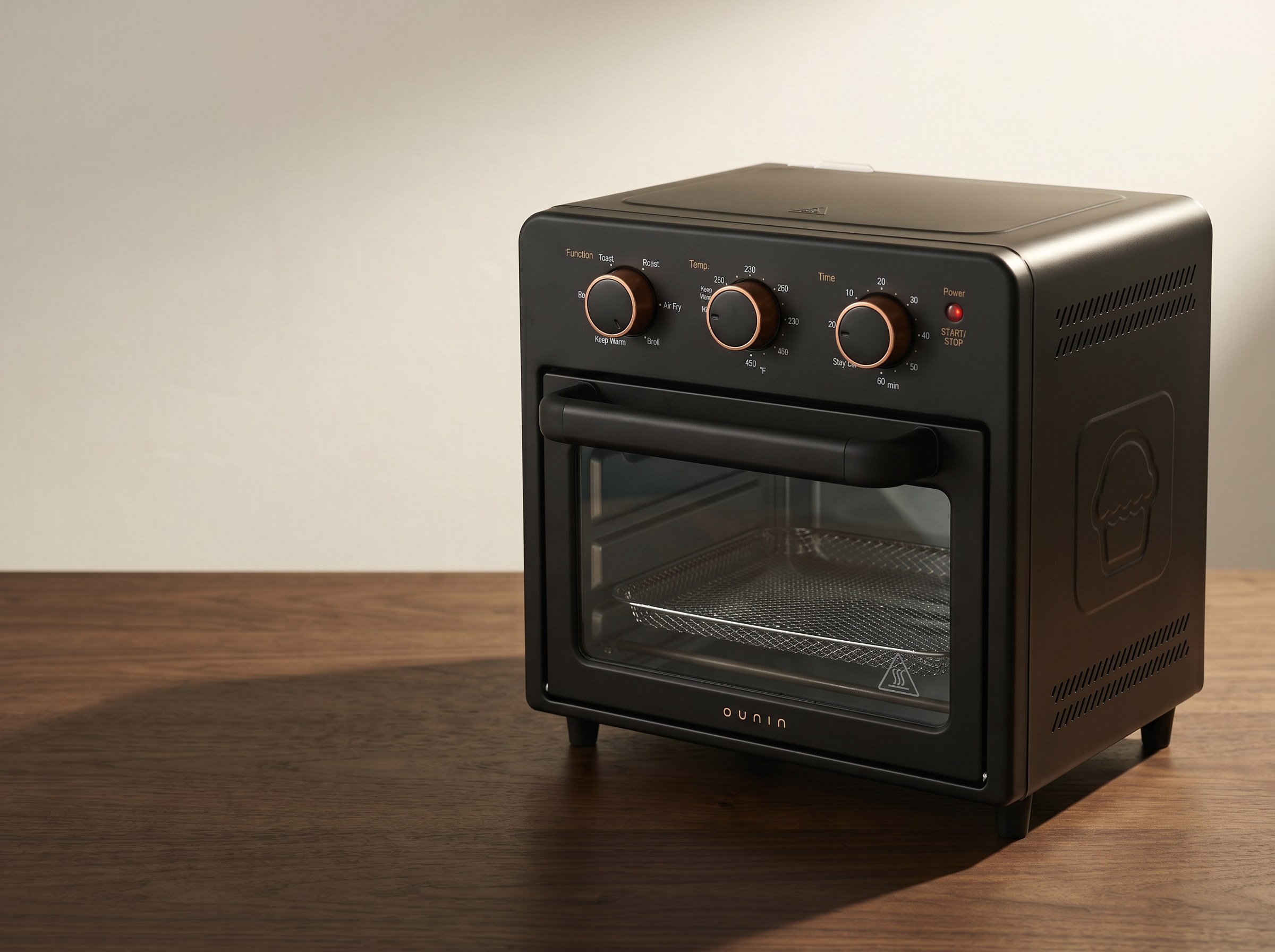 The Air Fryer Oven in warm sidelight, copper-ringed mechanical dials